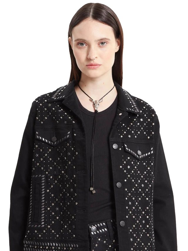 Campera de jean negra con tachas y piedras aplicadas en bolsillos, hombros y espalda, sobre pantalón con piedras al tono